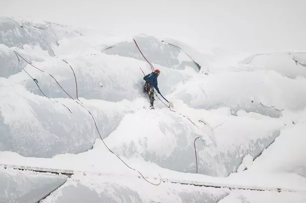 Bayern’s snow-covered stadium just like Mount Everest as brave man spotted climbing it